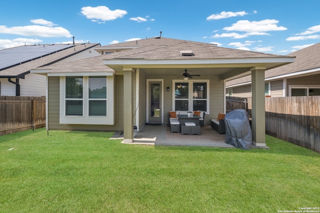 rear view of house with a yard, ceiling fan, solar panels, an outdoor living space, and a patio