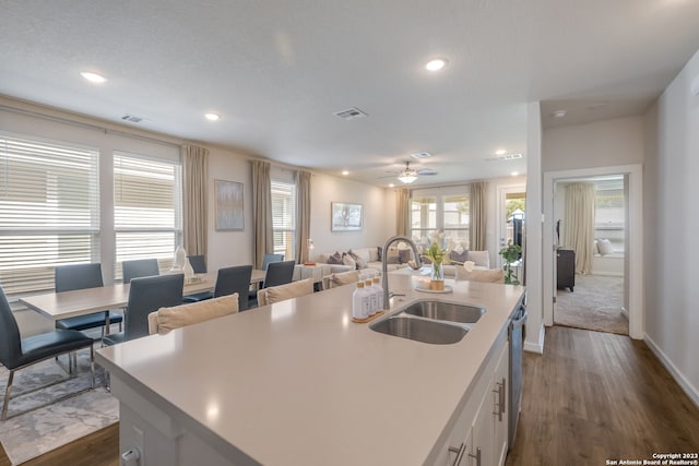 kitchen featuring ceiling fan, sink, dark hardwood / wood-style flooring, white cabinets, and a center island with sink