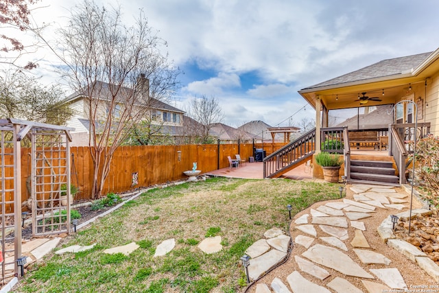 view of yard featuring a deck, ceiling fan, and a patio area