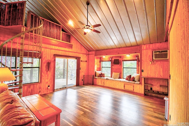 living room with wooden walls, plenty of natural light, and wood-type flooring