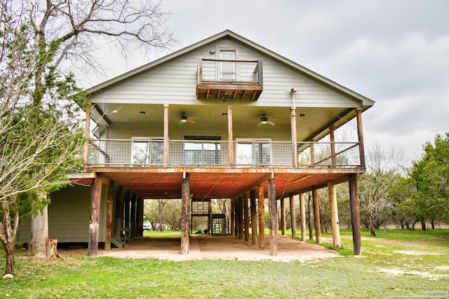 rear view of property featuring a deck, a yard, and a carport