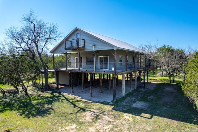 rear view of house featuring a porch and a yard