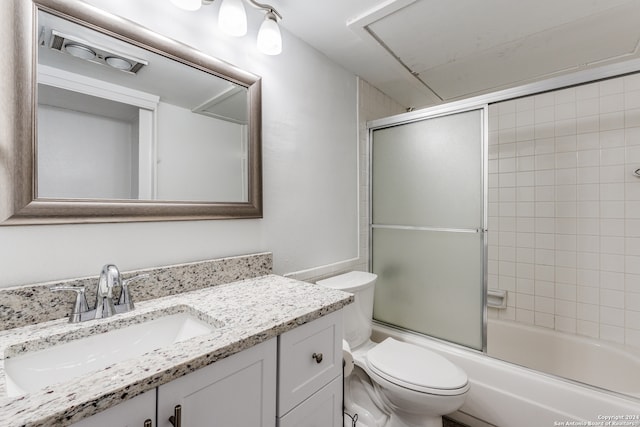 full bathroom with combined bath / shower with glass door, toilet, and vanity