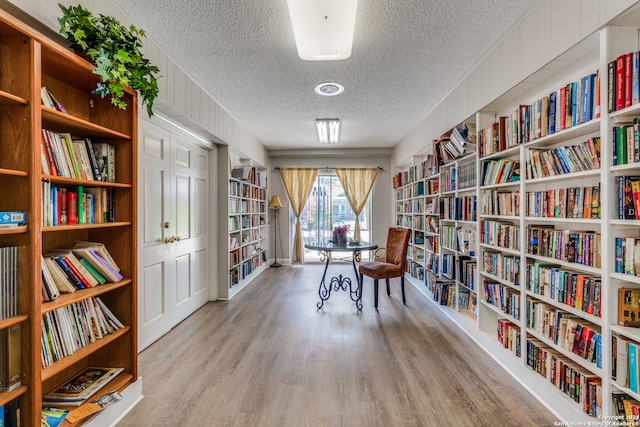 interior space with a textured ceiling and light hardwood / wood-style flooring