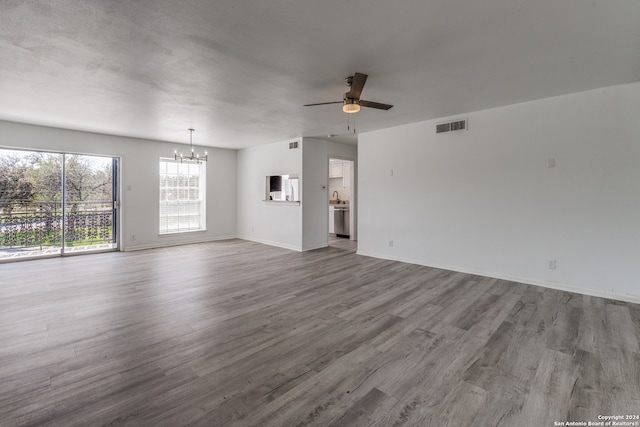 unfurnished living room featuring dark hardwood / wood-style floors and ceiling fan with notable chandelier