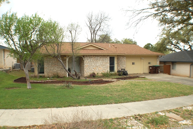 ranch-style home featuring a garage, central AC unit, and a front lawn