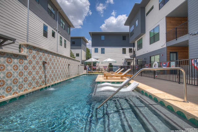 view of pool featuring pool water feature and a patio