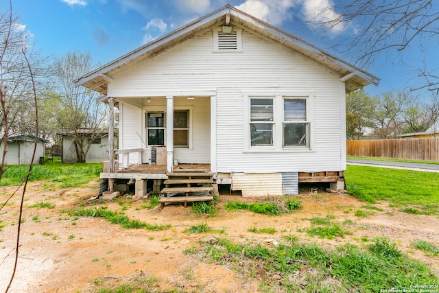 rear view of property featuring covered porch