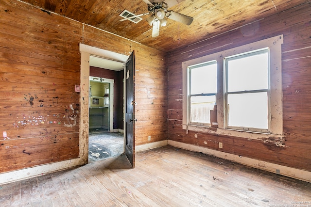 spare room featuring wooden walls, wood ceiling, and light hardwood / wood-style floors