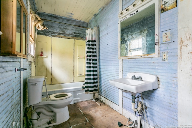 full bathroom featuring toilet, sink, wood walls, and shower / tub combo with curtain