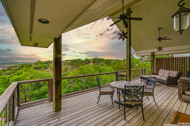 deck at dusk featuring outdoor lounge area and ceiling fan