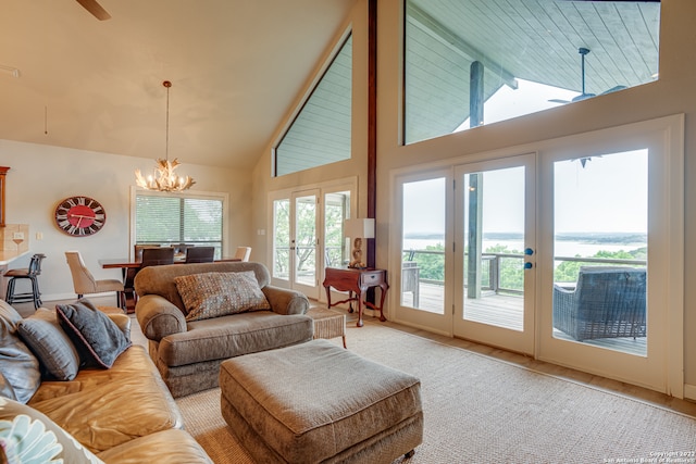 living room featuring french doors, ceiling fan with notable chandelier, and high vaulted ceiling