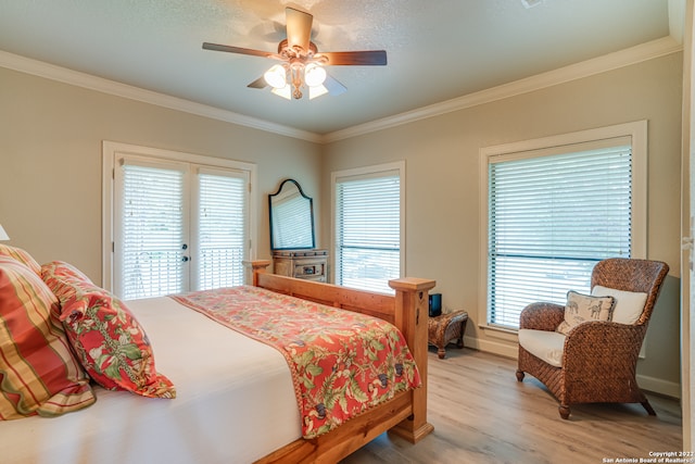 bedroom featuring ceiling fan, light wood-type flooring, access to outside, crown molding, and french doors