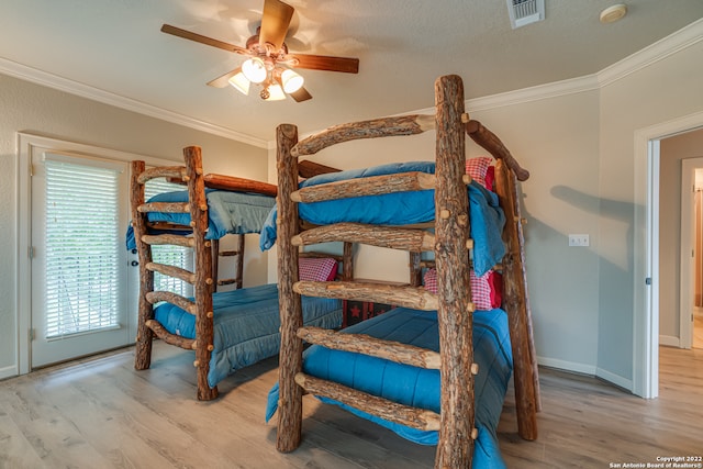 bedroom featuring light hardwood / wood-style floors, ornamental molding, a textured ceiling, and ceiling fan