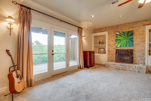 living room with ceiling fan, ornamental molding, a fireplace, and light carpet