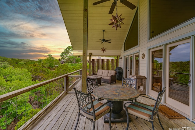 deck at dusk featuring ceiling fan and an outdoor living space