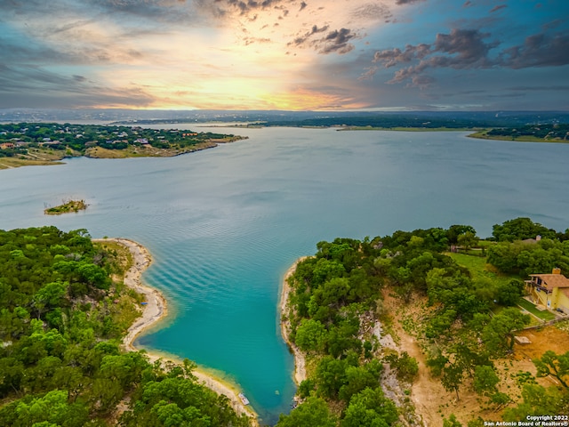 aerial view at dusk featuring a water view