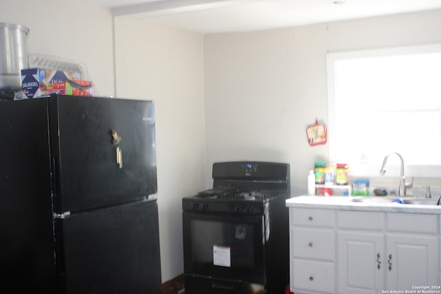 kitchen with white cabinets, black appliances, and sink