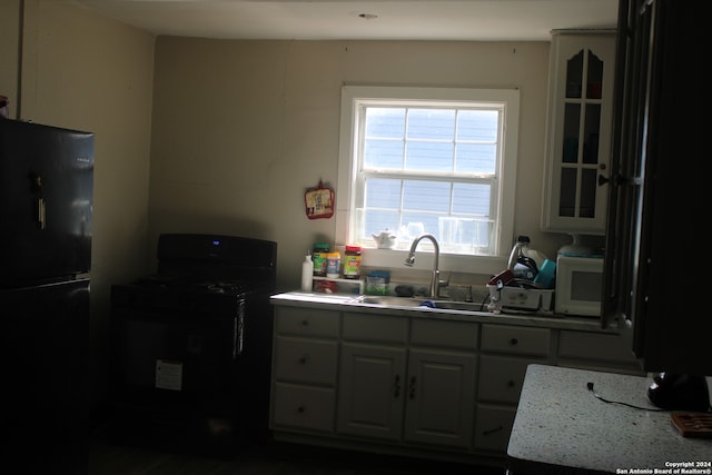 kitchen featuring black refrigerator, range, and sink