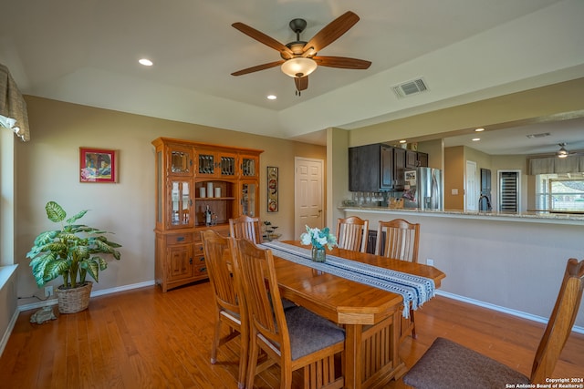 dining space with ceiling fan, sink, and light hardwood / wood-style floors