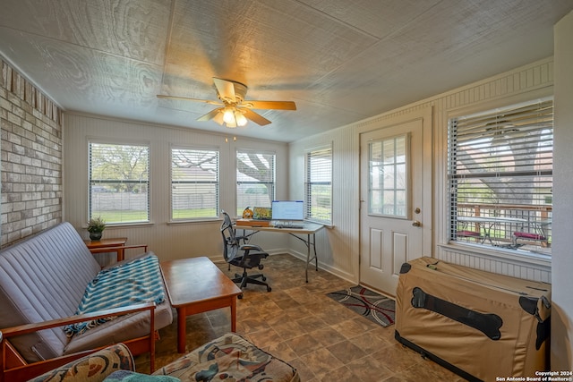 tiled office with ceiling fan and brick wall