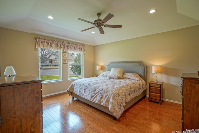 bedroom featuring ceiling fan, a raised ceiling, and hardwood / wood-style flooring