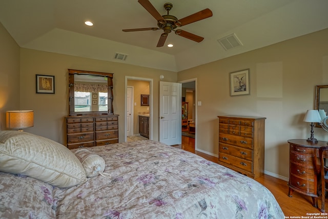 bedroom with ensuite bath, wood-type flooring, and ceiling fan