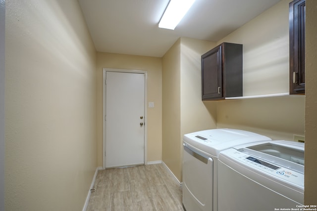 washroom featuring cabinets, light hardwood / wood-style flooring, and independent washer and dryer