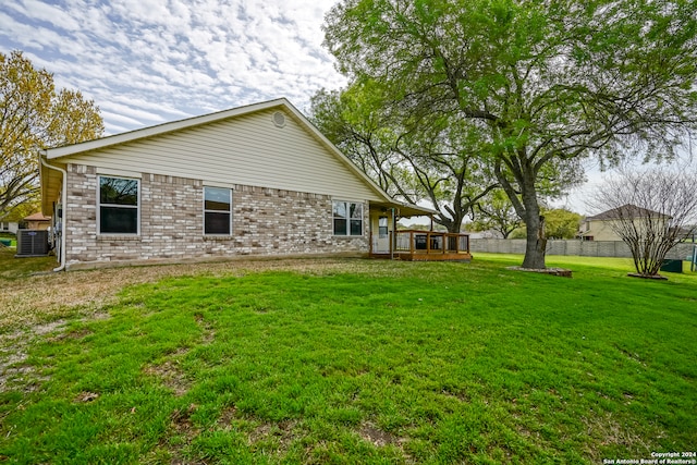 exterior space with central AC unit and a lawn