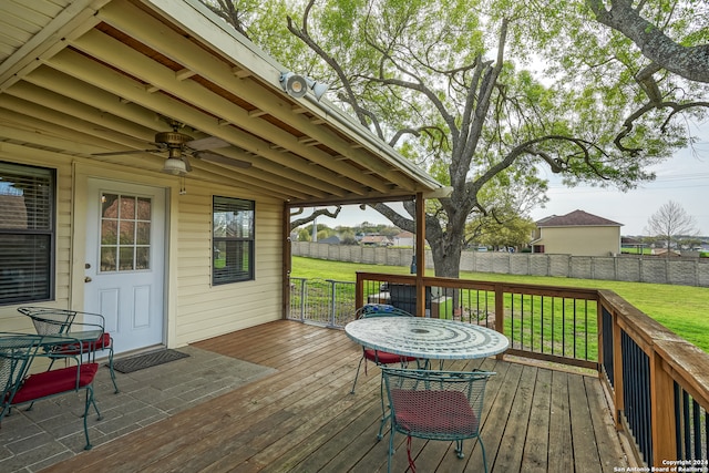 wooden deck with ceiling fan and a lawn