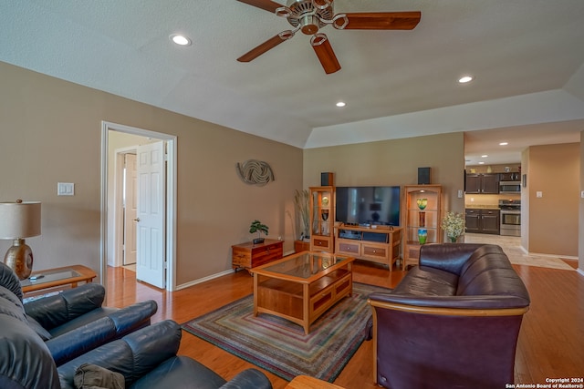 living room featuring ceiling fan, wood-type flooring, and lofted ceiling