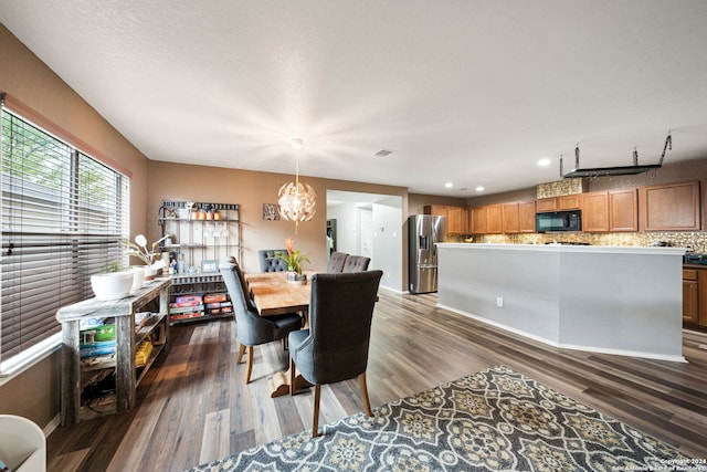 dining space with a notable chandelier and dark hardwood / wood-style floors