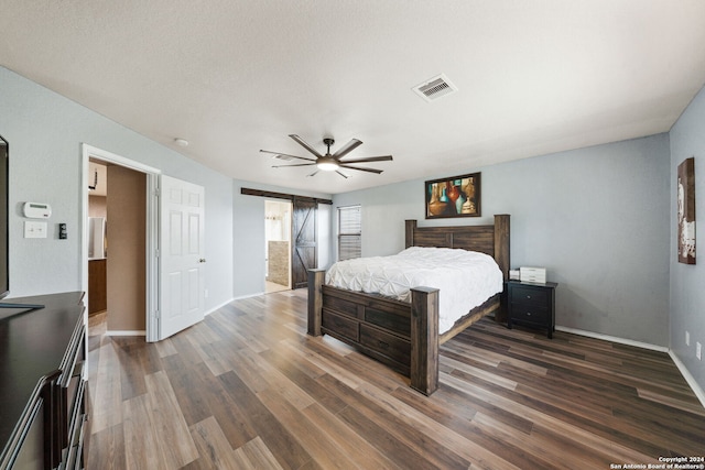 bedroom with ceiling fan, dark wood-type flooring, and a textured ceiling