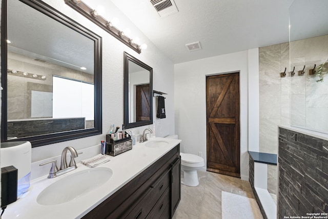 bathroom featuring toilet, tile floors, dual sinks, and large vanity