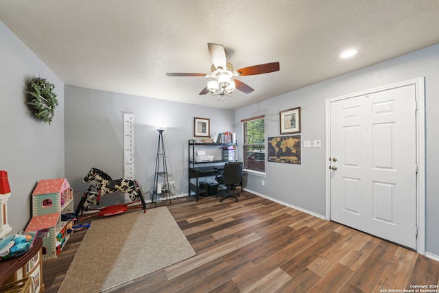 interior space with a textured ceiling, ceiling fan, and dark hardwood / wood-style flooring