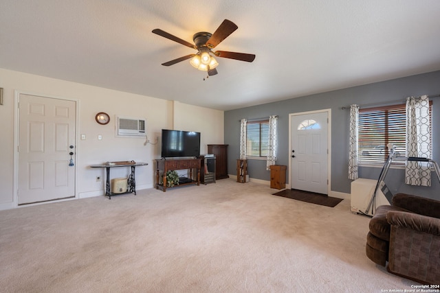 living room featuring an AC wall unit, ceiling fan, and carpet