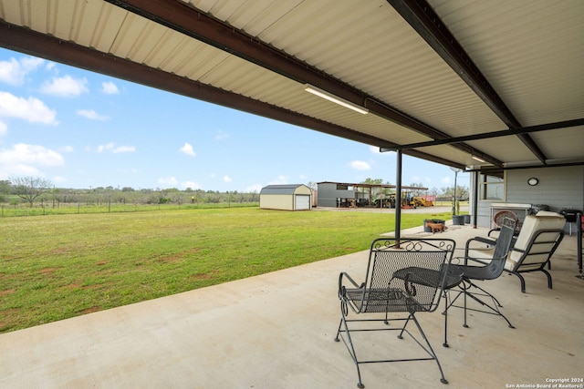 view of patio with a rural view and a shed