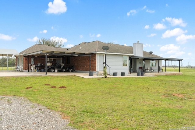 back of property with a lawn and a carport