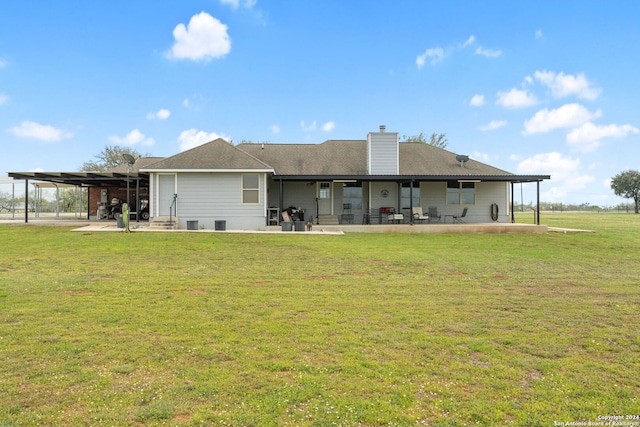 rear view of property with a yard, a carport, and a patio area