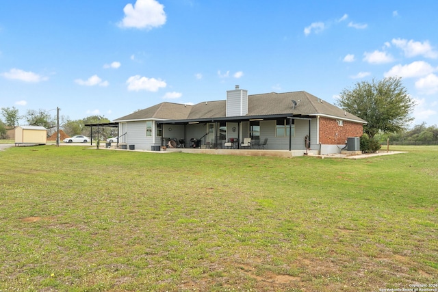 rear view of house featuring a patio, a lawn, and central air condition unit