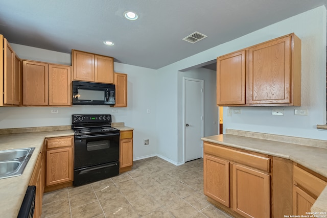 kitchen with light tile floors, black appliances, and sink