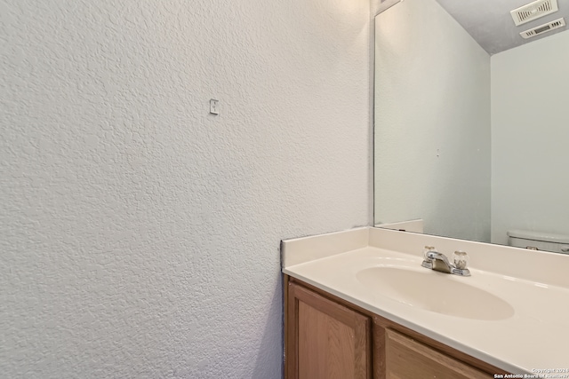 bathroom featuring toilet and vanity