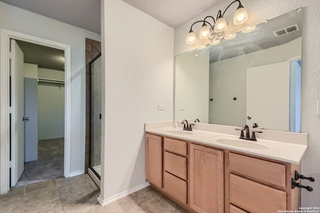 bathroom featuring double sink vanity, tile flooring, and a shower with shower door