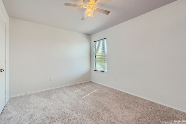 carpeted empty room featuring ceiling fan