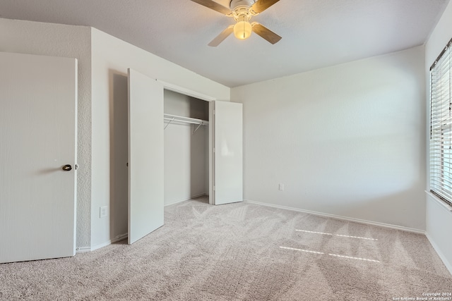 unfurnished bedroom with ceiling fan, light carpet, and a closet