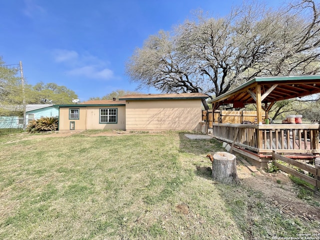 rear view of house with a deck and a lawn