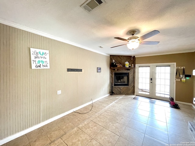 unfurnished living room featuring light tile floors, ceiling fan, french doors, and a fireplace