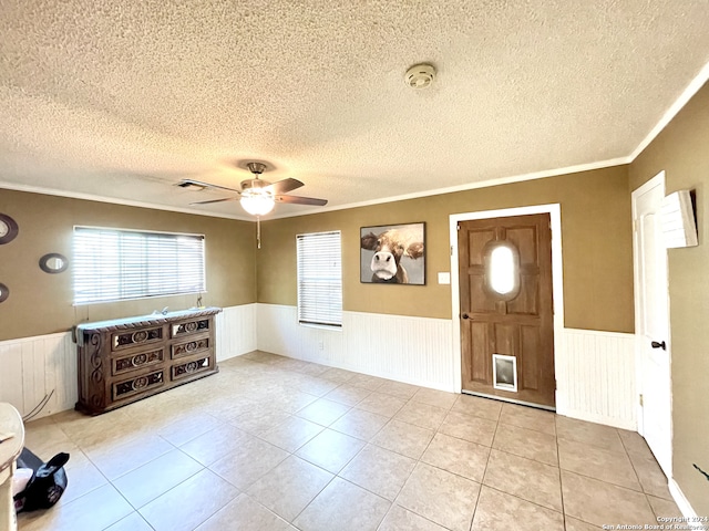 foyer entrance with crown molding, a textured ceiling, ceiling fan, and light tile floors