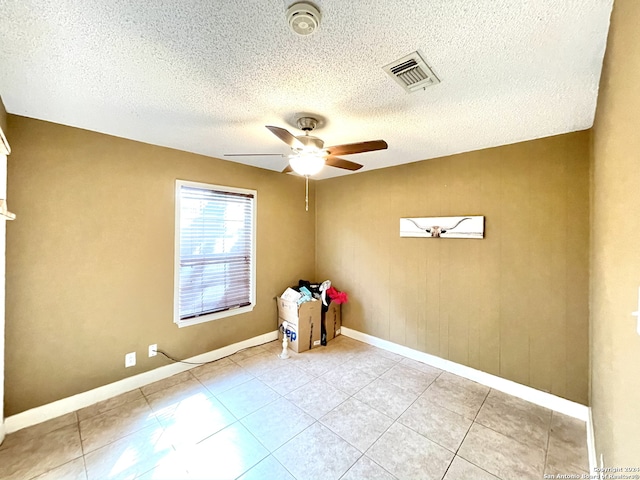 tiled spare room featuring ceiling fan and a textured ceiling