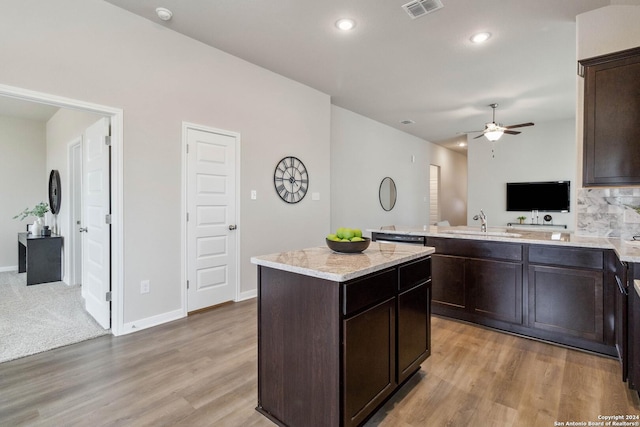 kitchen featuring ceiling fan, a kitchen island, light wood-type flooring, and sink